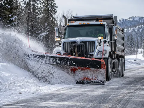 A plow truck clearing a snow-covered road — an illustration of blade use
